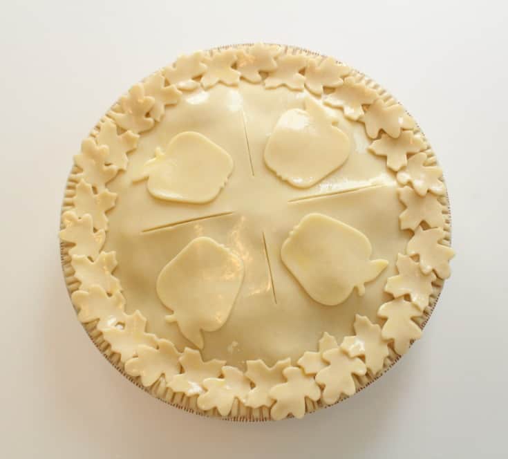 Adding the cut out pie crust shapes to the apple pie