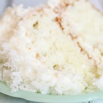 Slice of coconut cake on a green plate