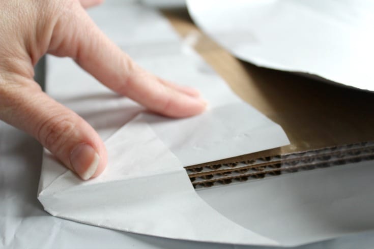 folding back the corners on the cake board