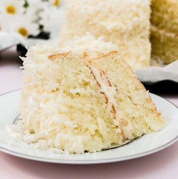 Close up image of coconut layer cake on a plate.