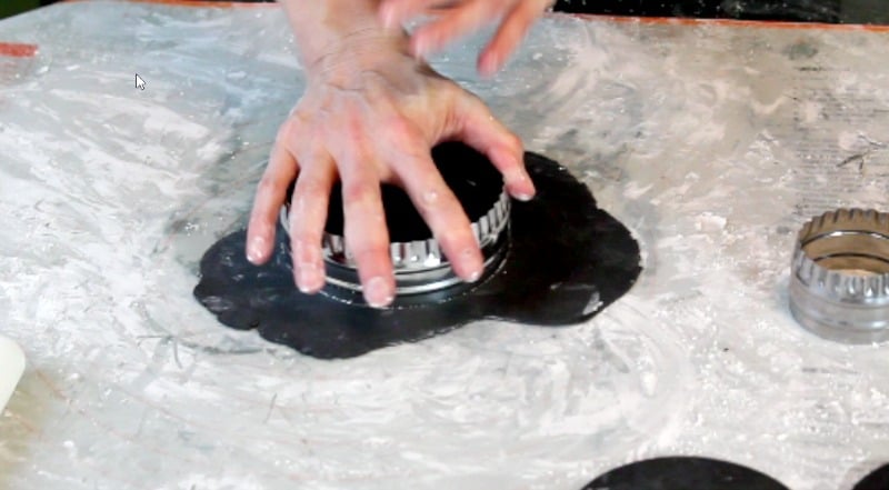 cutting black fondant circles for fidget spinner cake