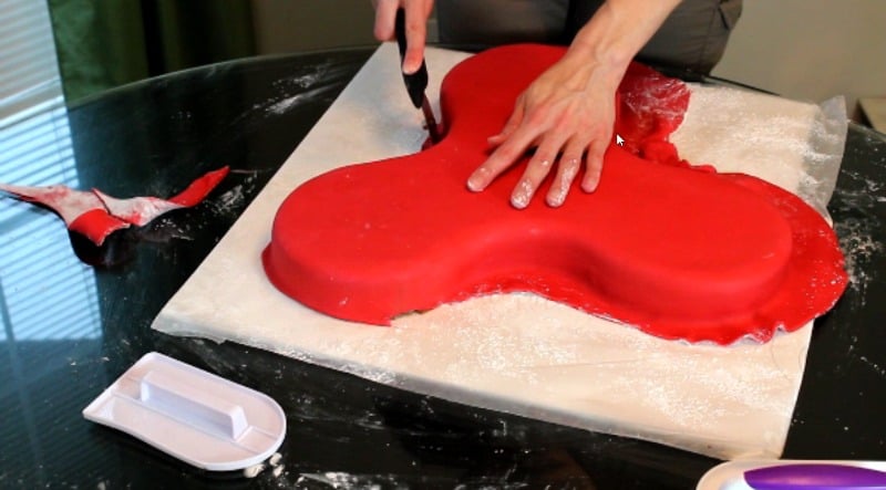 cutting fondant around fidget spinner cake