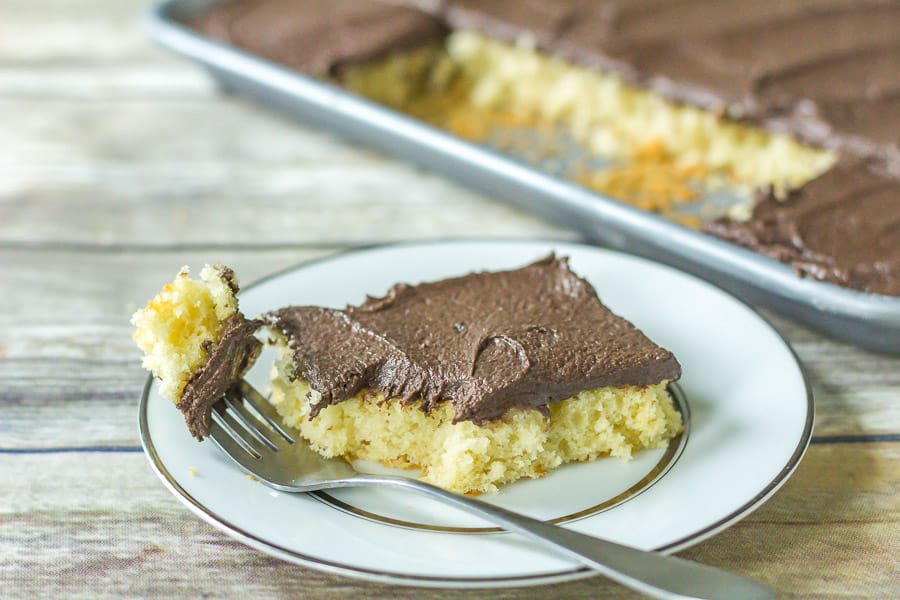 Yellow Buttermilk Sheet Cake with Fudge Frosting on a white plate with a fork