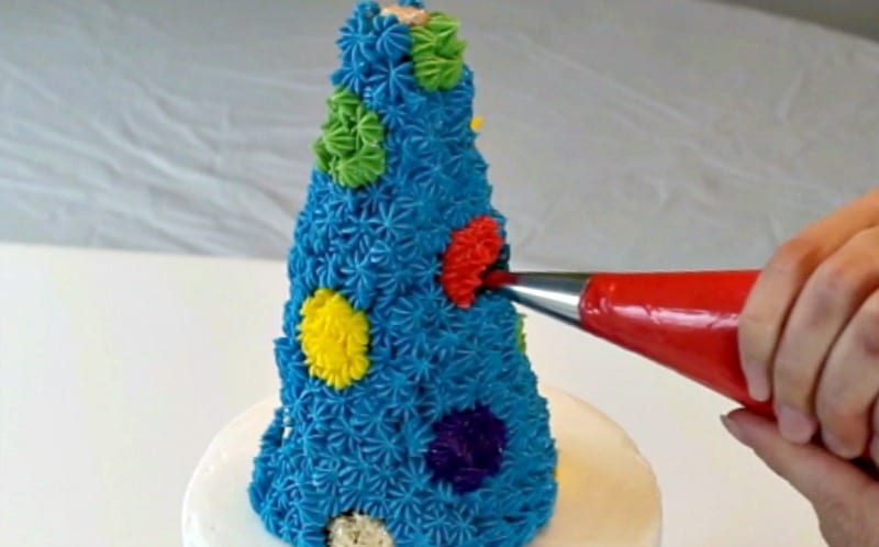 Piping red onto rice krispie treat party hat cake topper