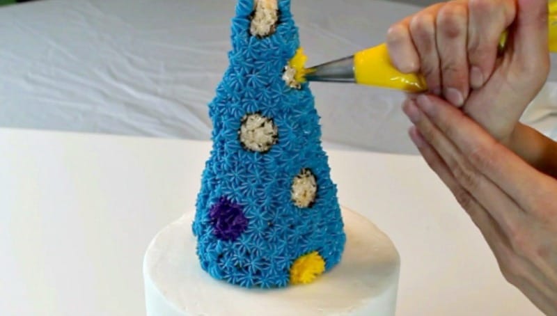 Piping onto rice krispie treat party hat cake topper