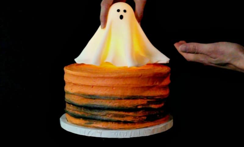 Adding fondant ghost to cake