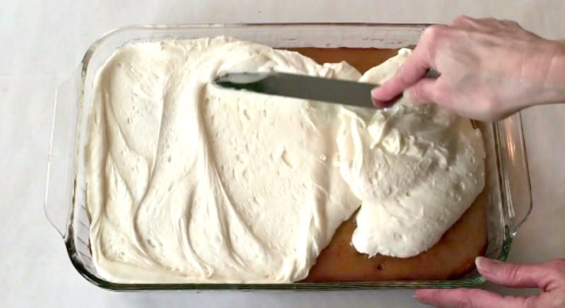 Adding marshmallow buttercream to cake