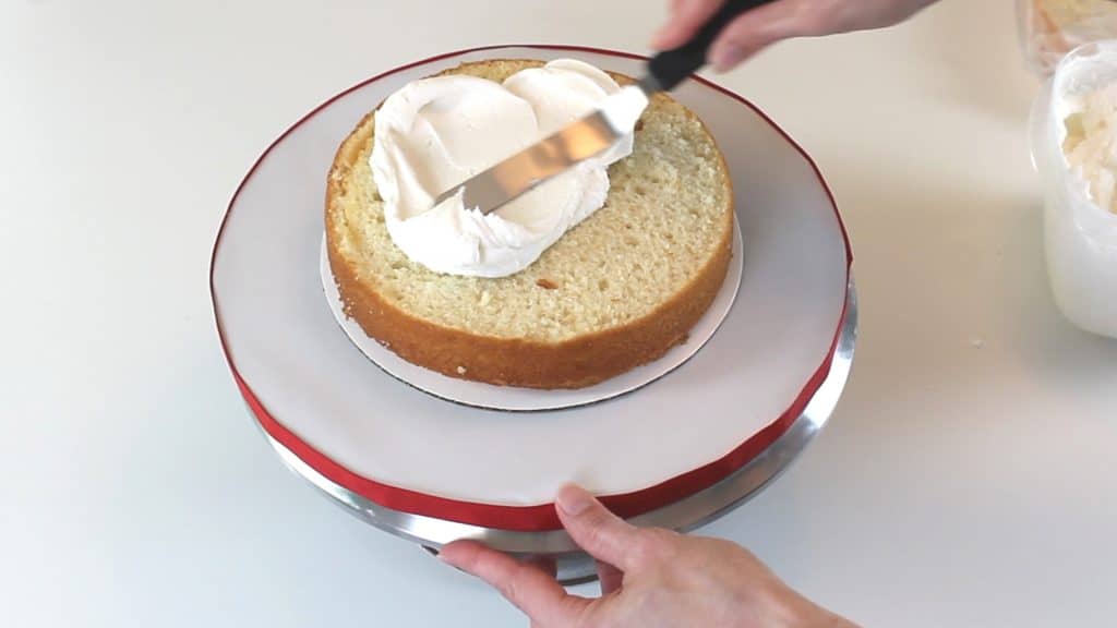 Adding buttercream filling to cake