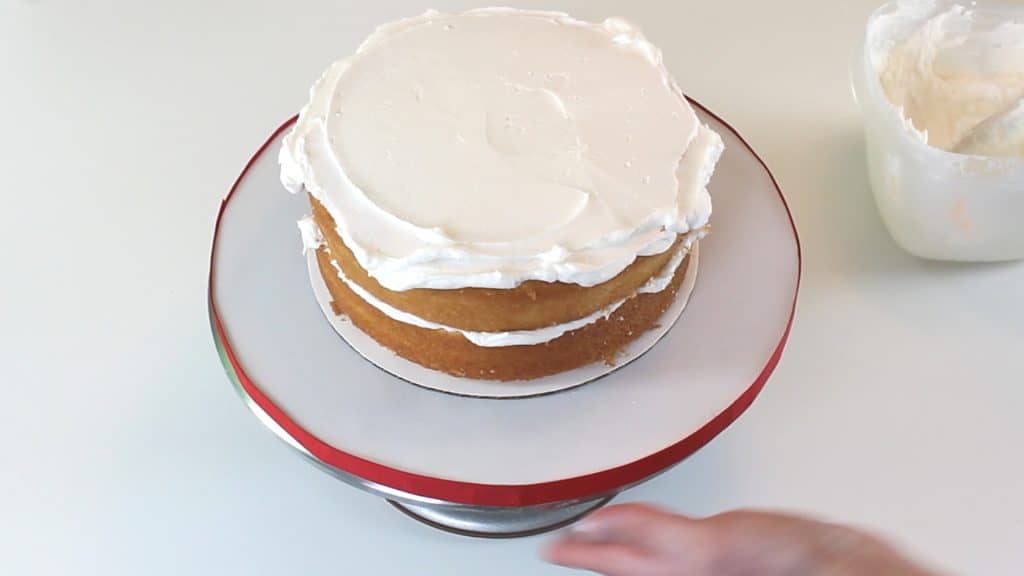 Smoothing buttercream layer on cake
