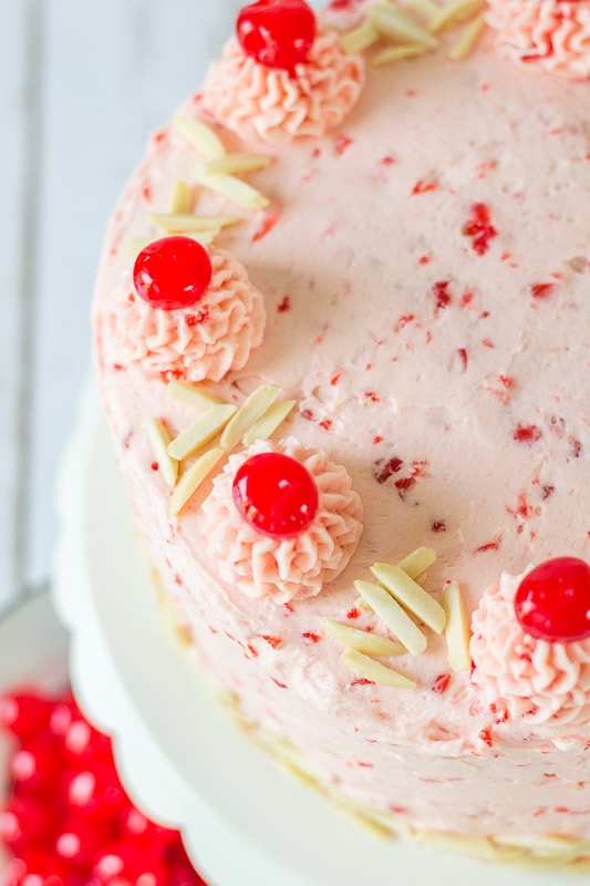 top close up view of almond cake with cherries on top