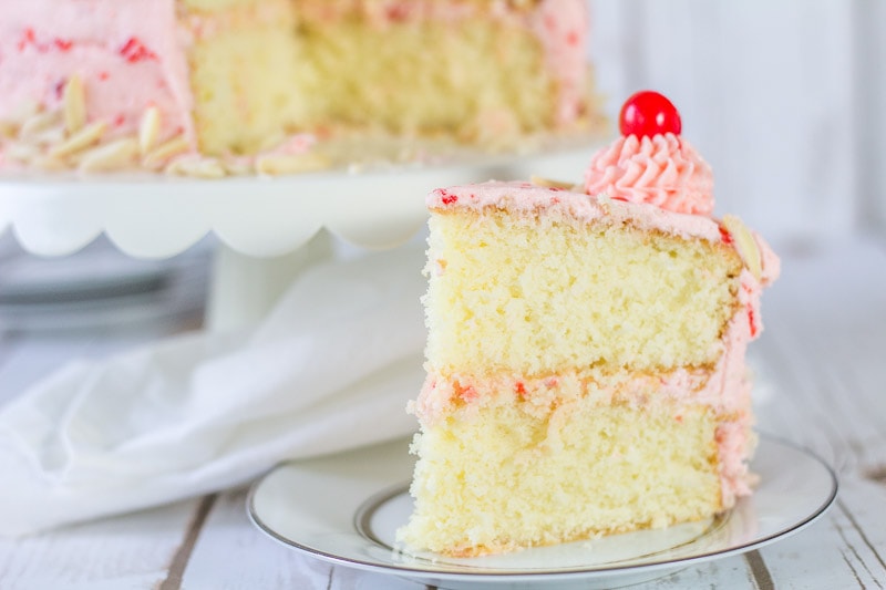 cut piece of almond cake with cherry buttercream