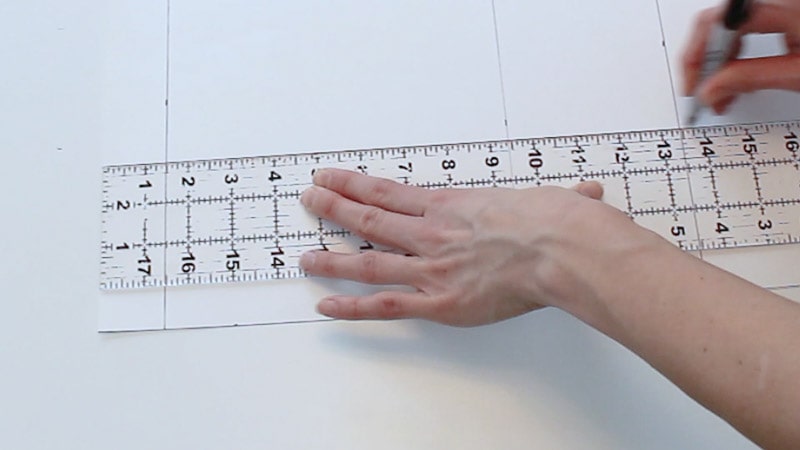 drawing a line to connect the measurements on the poster board