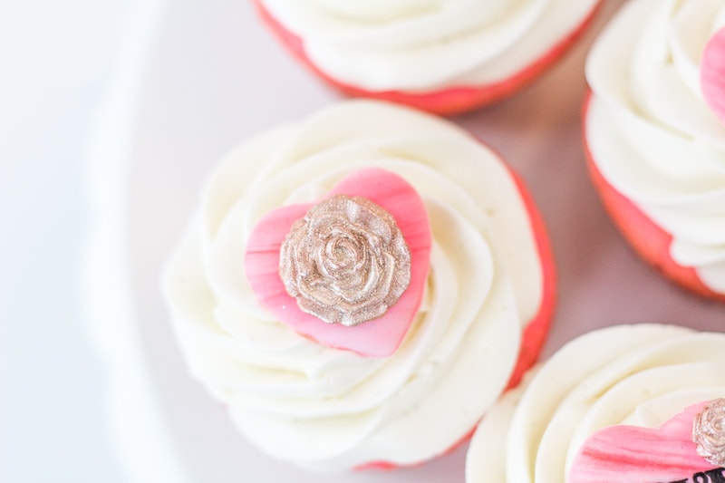 close up of valentine's cupcake topper with gold fondant rose