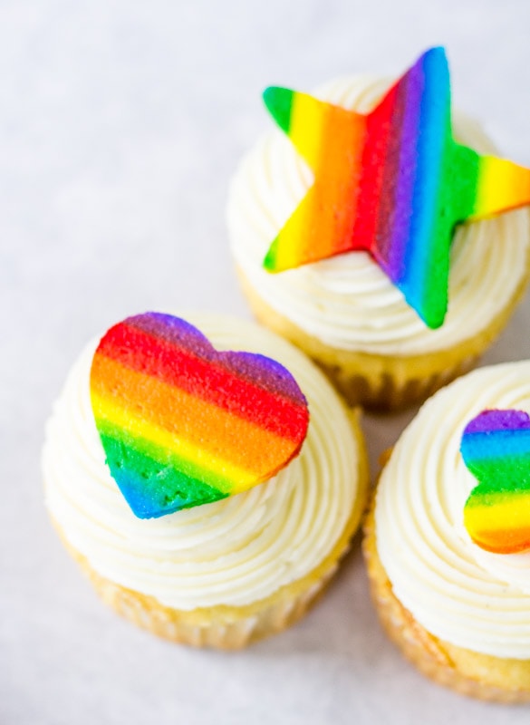 closeup of rainbow buttercream cutouts on cupcakes