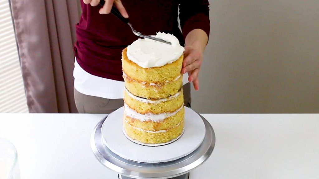 Add buttercream to the top of tall cake