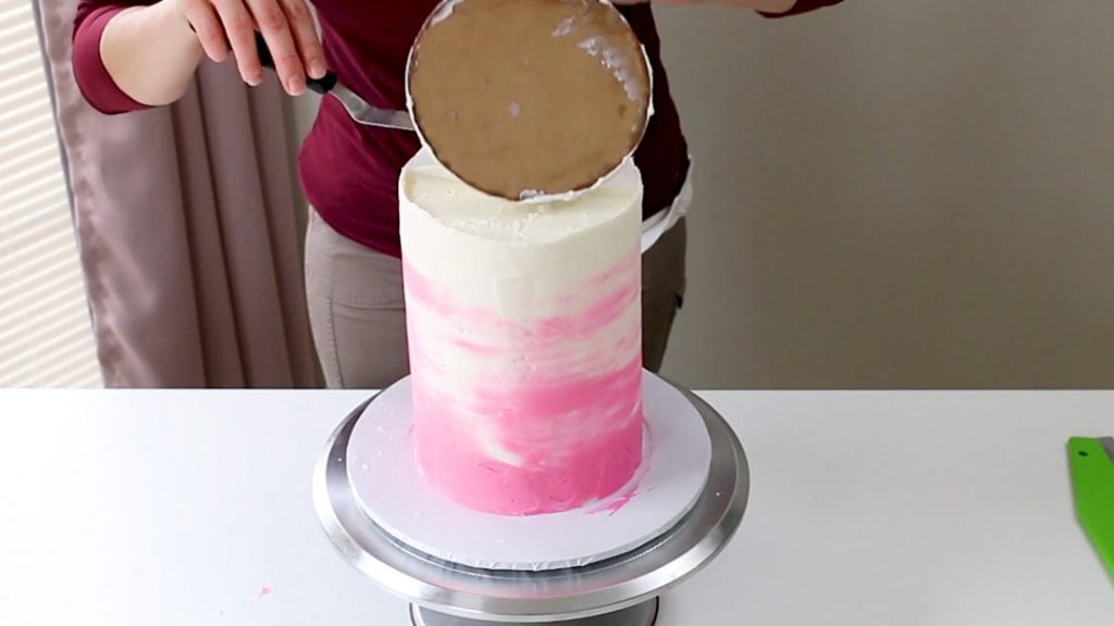 Taking off the top cake board on a tall cake