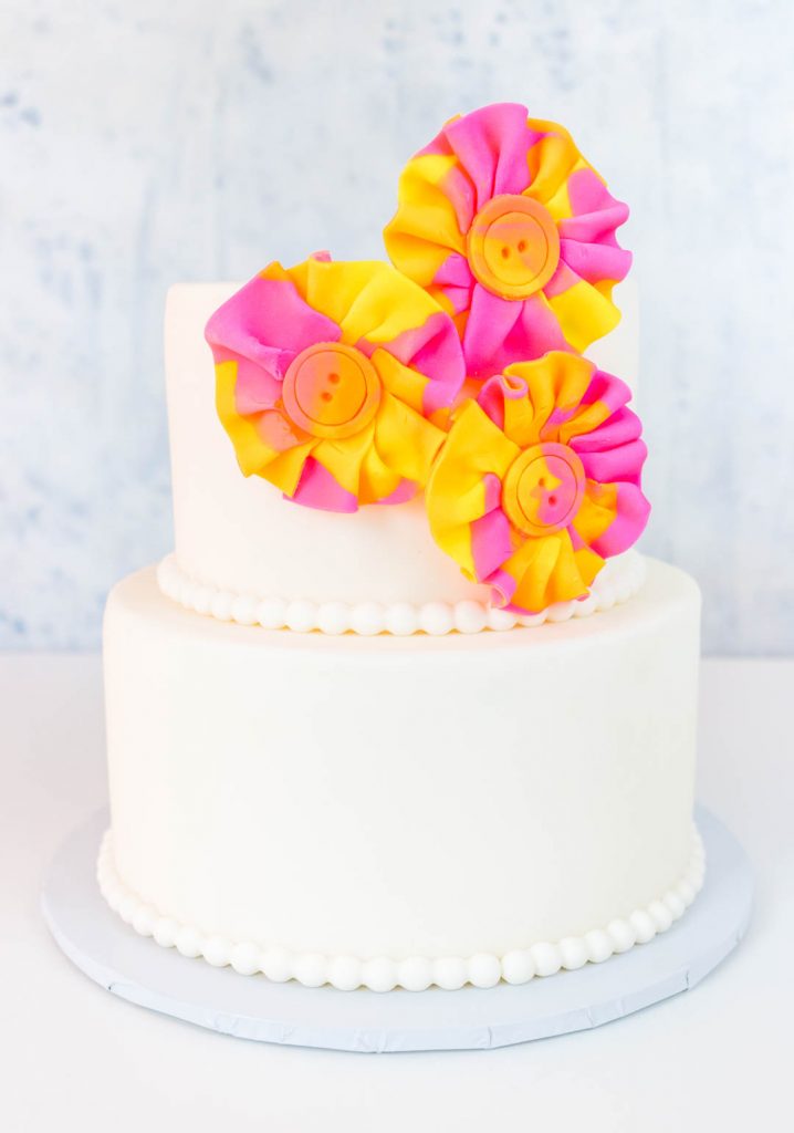 Two tiered white cake with watercolor fondant flowers