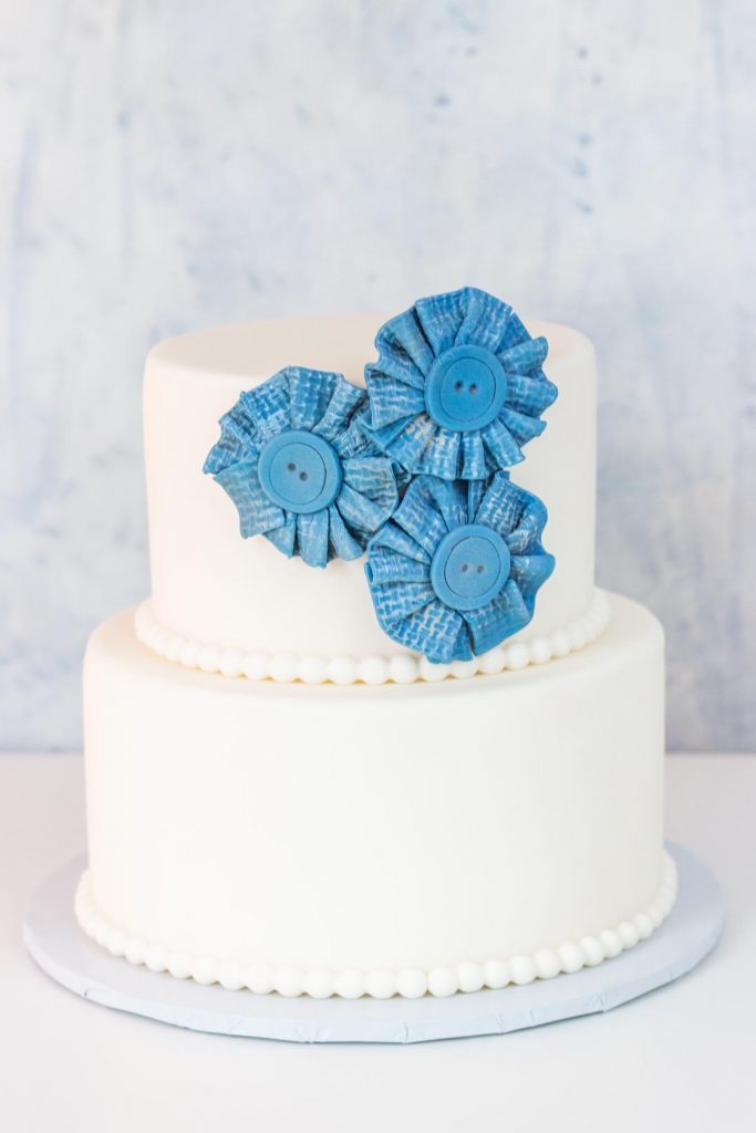 blue jean fondant button flowers on a two tiered cake