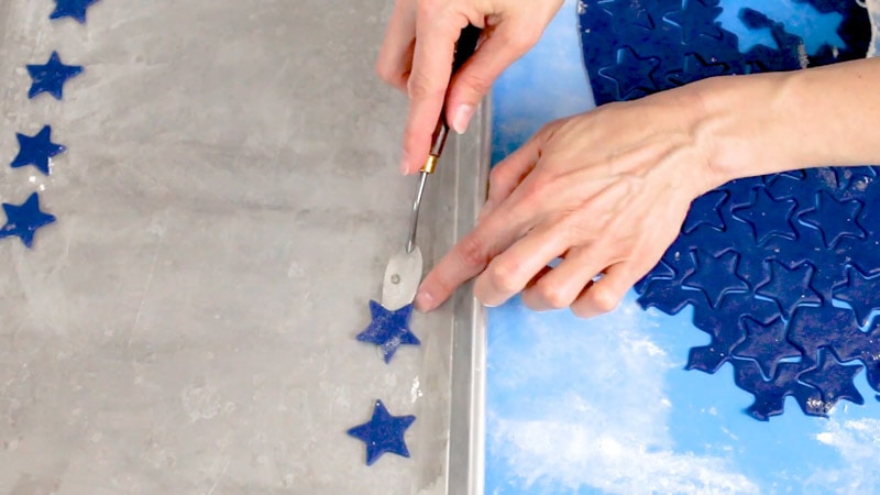 Placing blue star cookie dough onto cookie pan