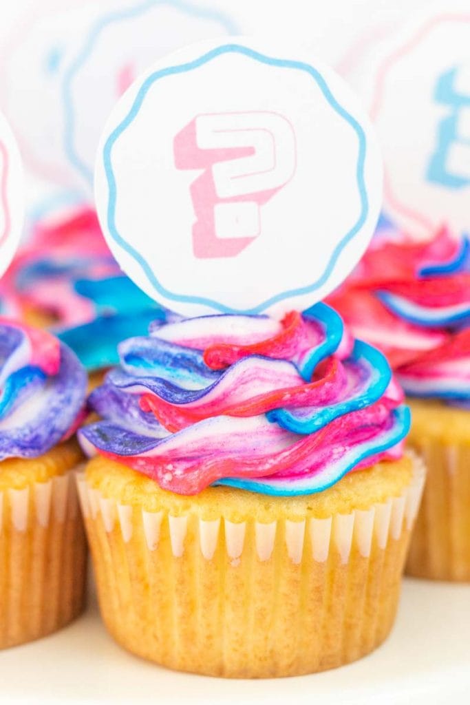 Gender reveal cupcakes with pastel cupcake toppers close up view