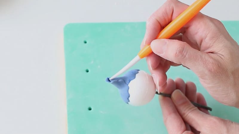 Adding the gumpaste petal around the styrofoam ball