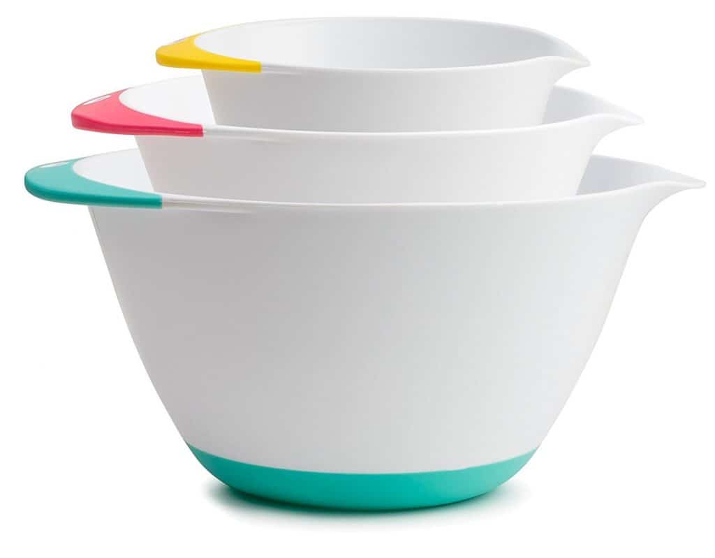 Set of three white mixing bowls with colored handles and bottoms.