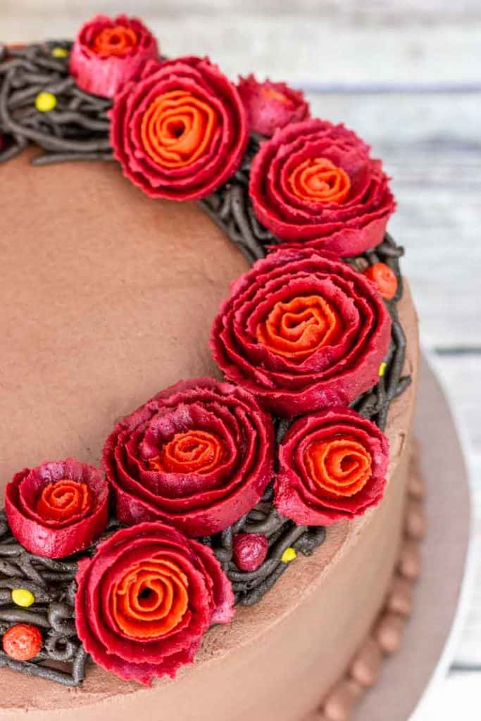 Close up view of red buttercream roses on a wreath cake