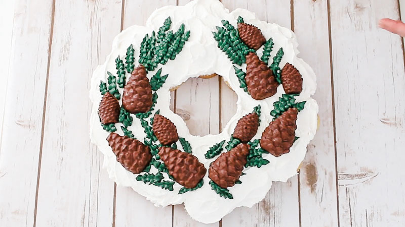 adding the chocolate pine cones to the wreath cupcake cake