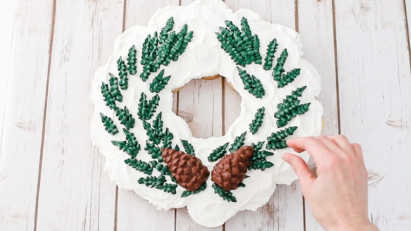 adding chocolate pine cones to the wreath cake
