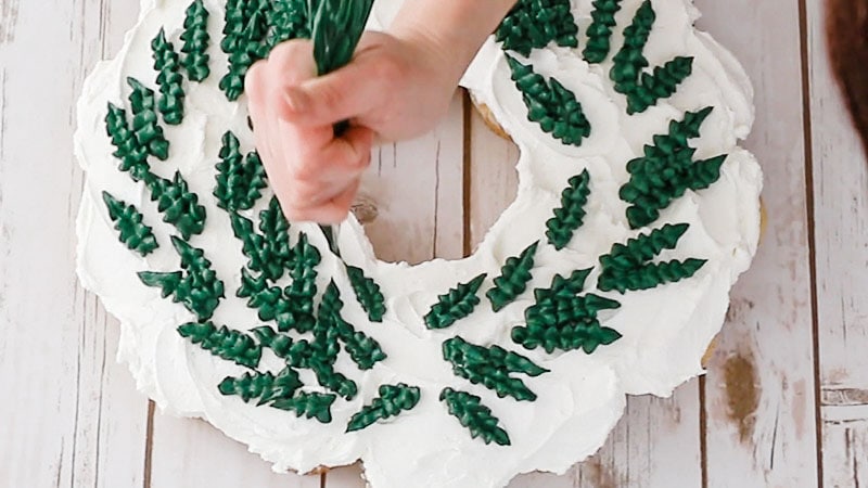 piping leaves onto cupcake wreath cake