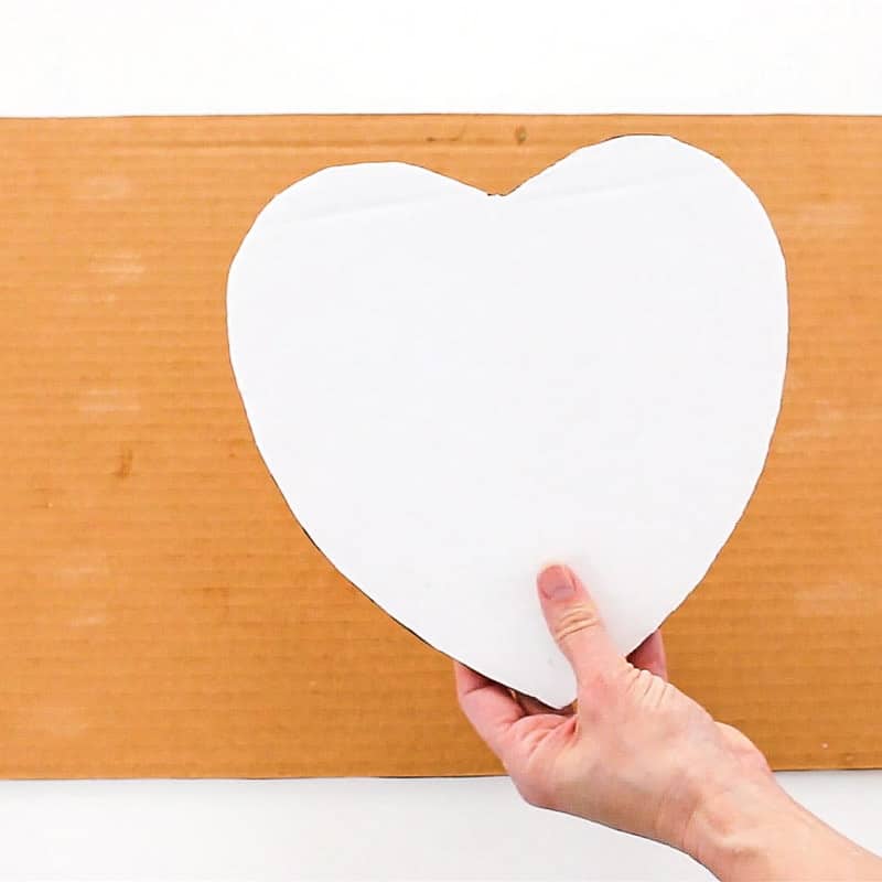 Cut out cardboard cake board in shape of the heart.