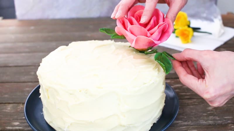 adjusting gumpaste roses on cake