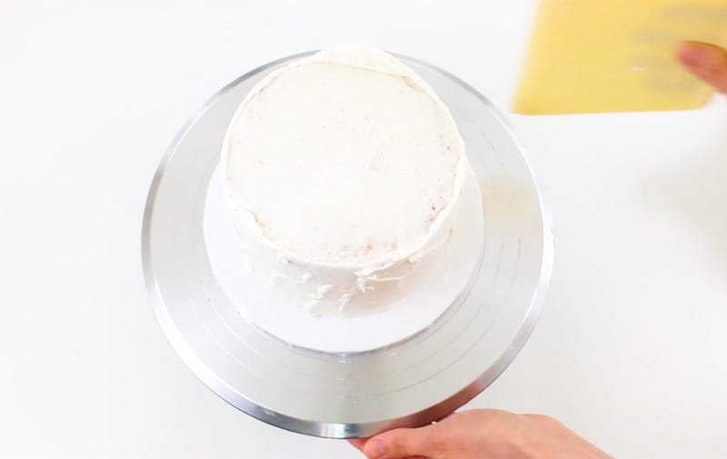 smoothing buttercream on the cake