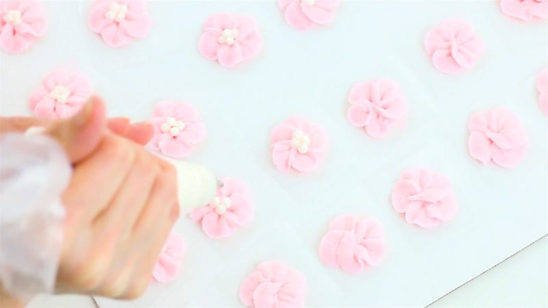 piping dots into centers of apple blossoms