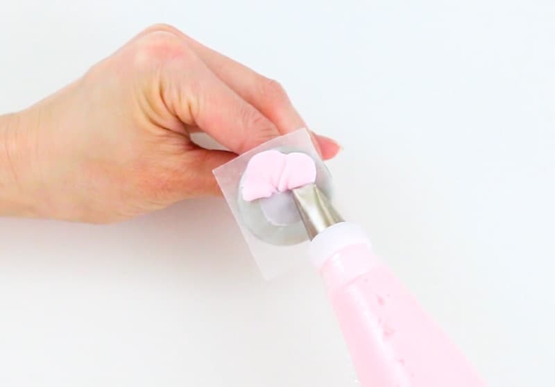 piping buttercream petals onto flower nail