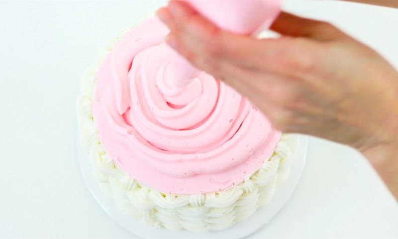 add buttercream to the top of cake