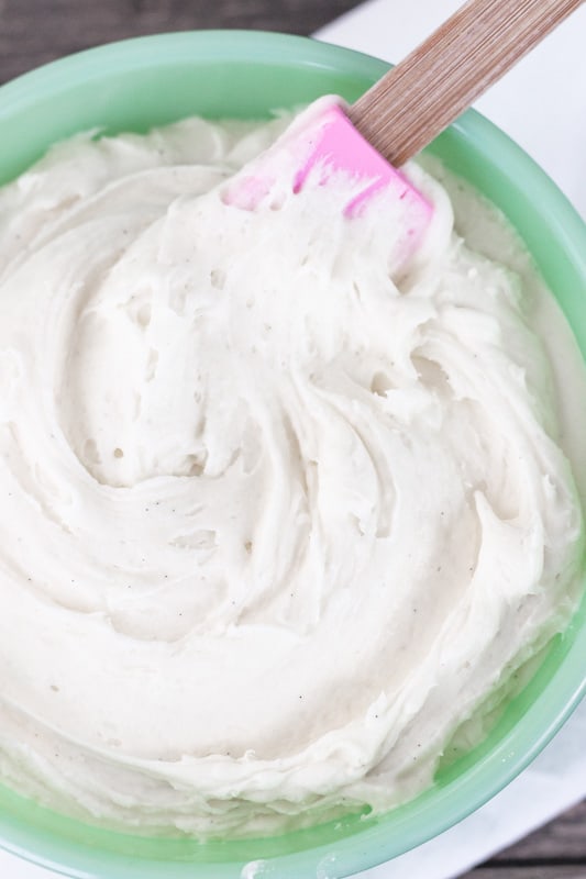 Fluffy Marshmallow Frosting with rubber spatula in a green bowl