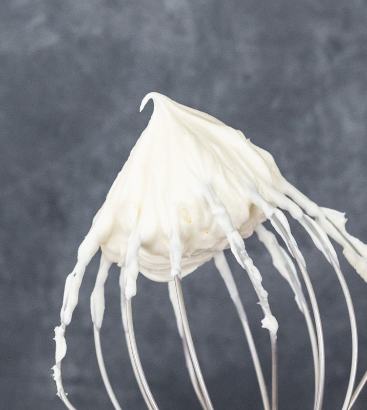 Whipped icing on the end of a large whisk attachment.