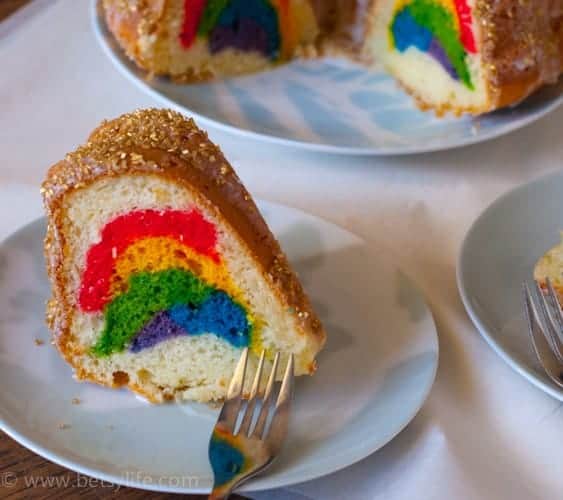 rainbow bundt cake slice on a white plate