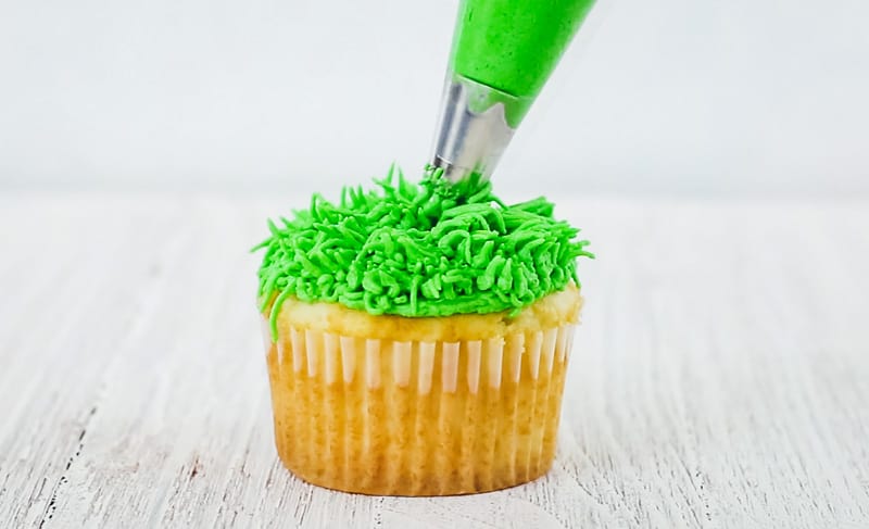 pipe green buttercream grass onto cupcakes