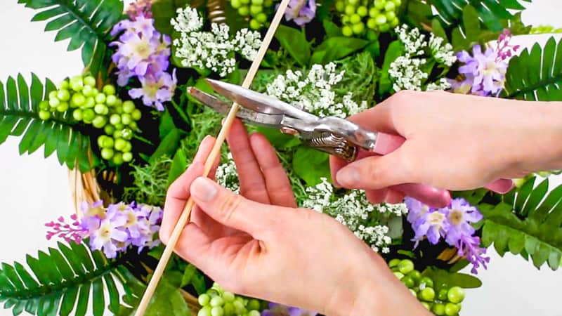 cutting wooden skewers in half for cupcake bouquet