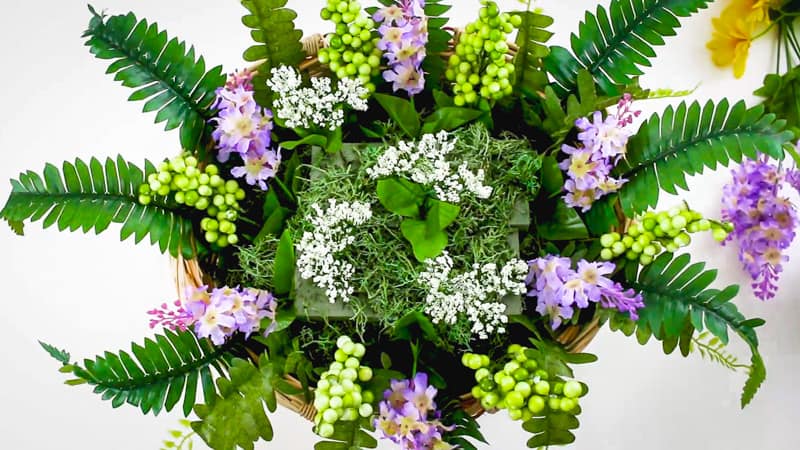 adding in smaller flowers to the cupcake basket