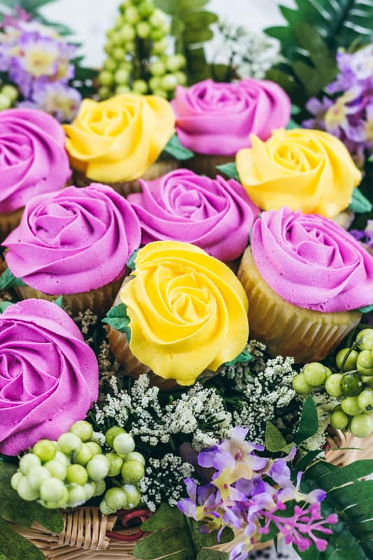 Very close up of purple and yellow rosette cupcakes.