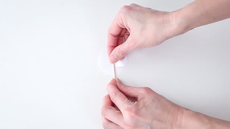 Attaching a toothpick to the back of the cupcake topper with tape.
