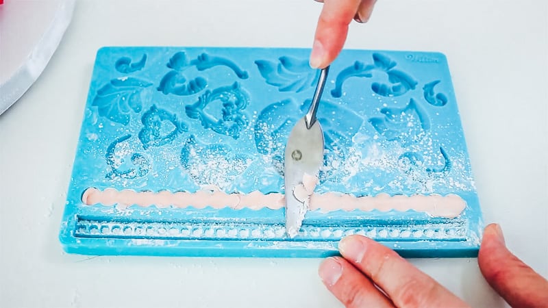 use palette knife to take off the excess fondant