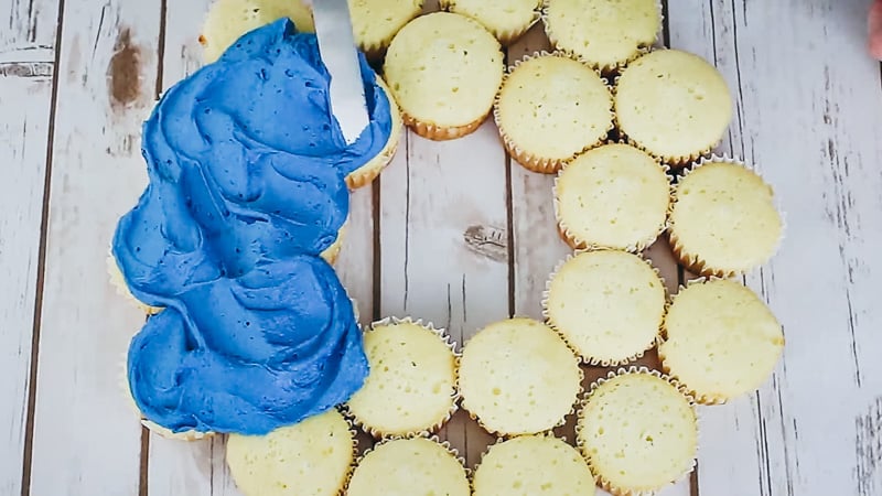 smooth blue buttercream onto cupcake cake