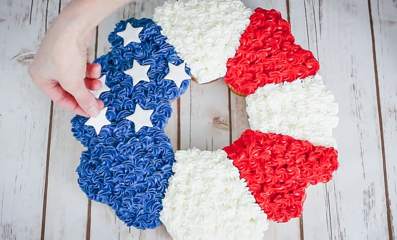 attaching the fondant stars to the cupcake cake