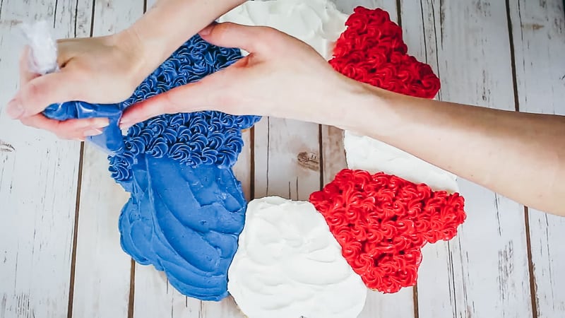 piping on the tiny rosettes to the cupcake cake