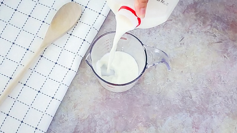 Pouring milk into a liquid measuring cup.