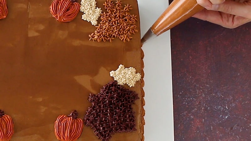 piping a chocolate shell border around the cake
